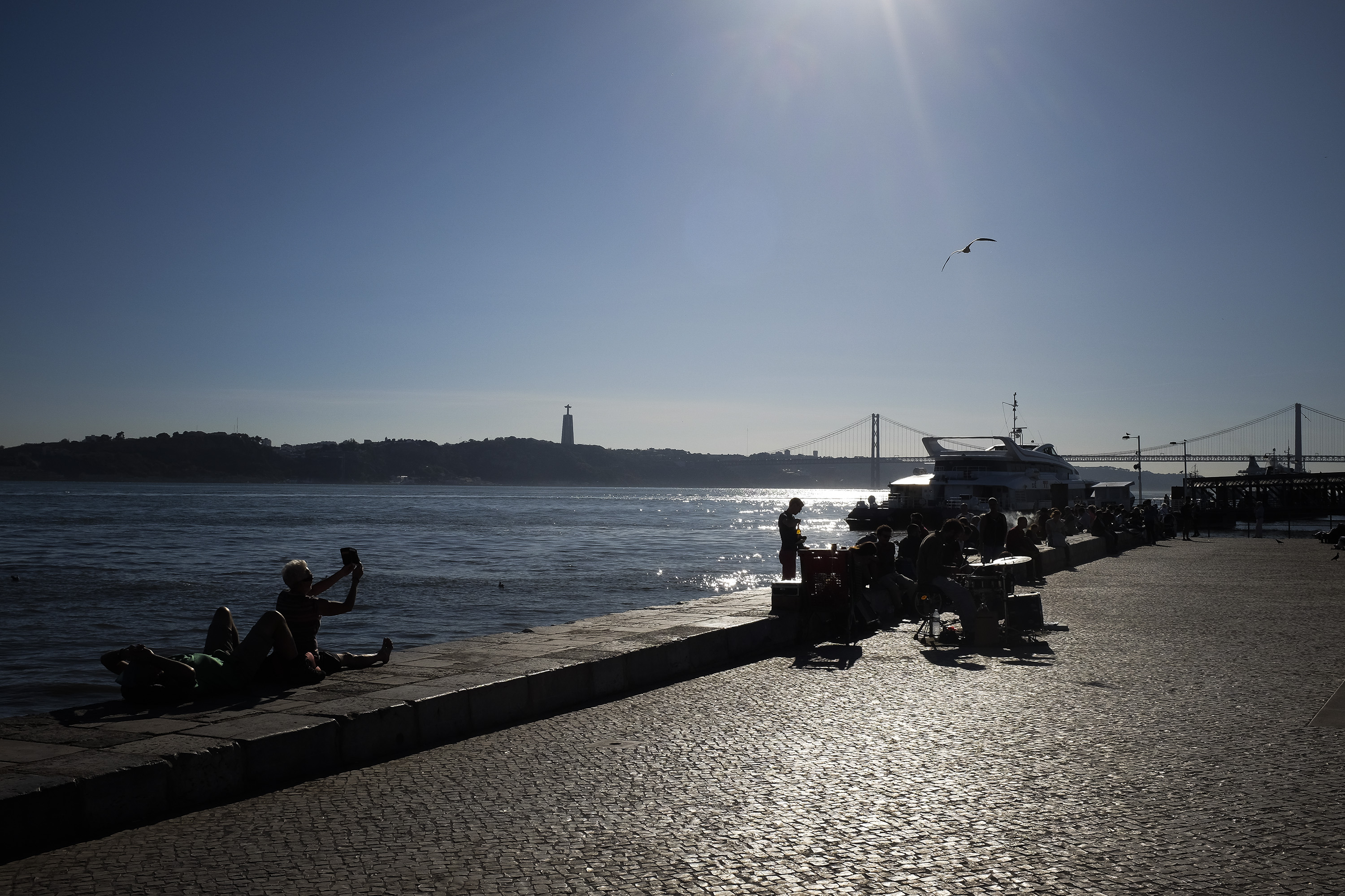 Tagus river by sunset in Lisbon, with a background bridge that shares some similarities with the Golden Gate in San Francisco